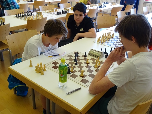 Laurin WISCHOUNIG (r.) gegen Andreas HIRZINGER (l.), genau betrachtet vom Mitkonkurrenten Gor TUMANYAN: Das Turmendspiel wäre trotz des schwarzen Freibauern auf d5 wahrscheinlich Remis.