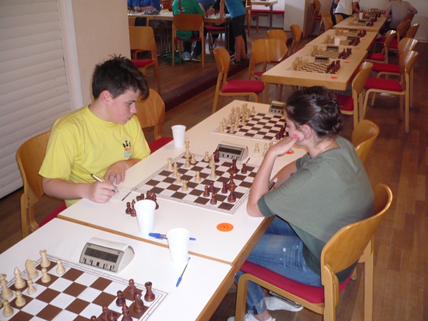 Victor NAT (li.) und Angelina ZHBANOVA (re.); trotz des Ungleichgewichts (Dame für Turm, Läufer und Bauer) steht Victor gut.